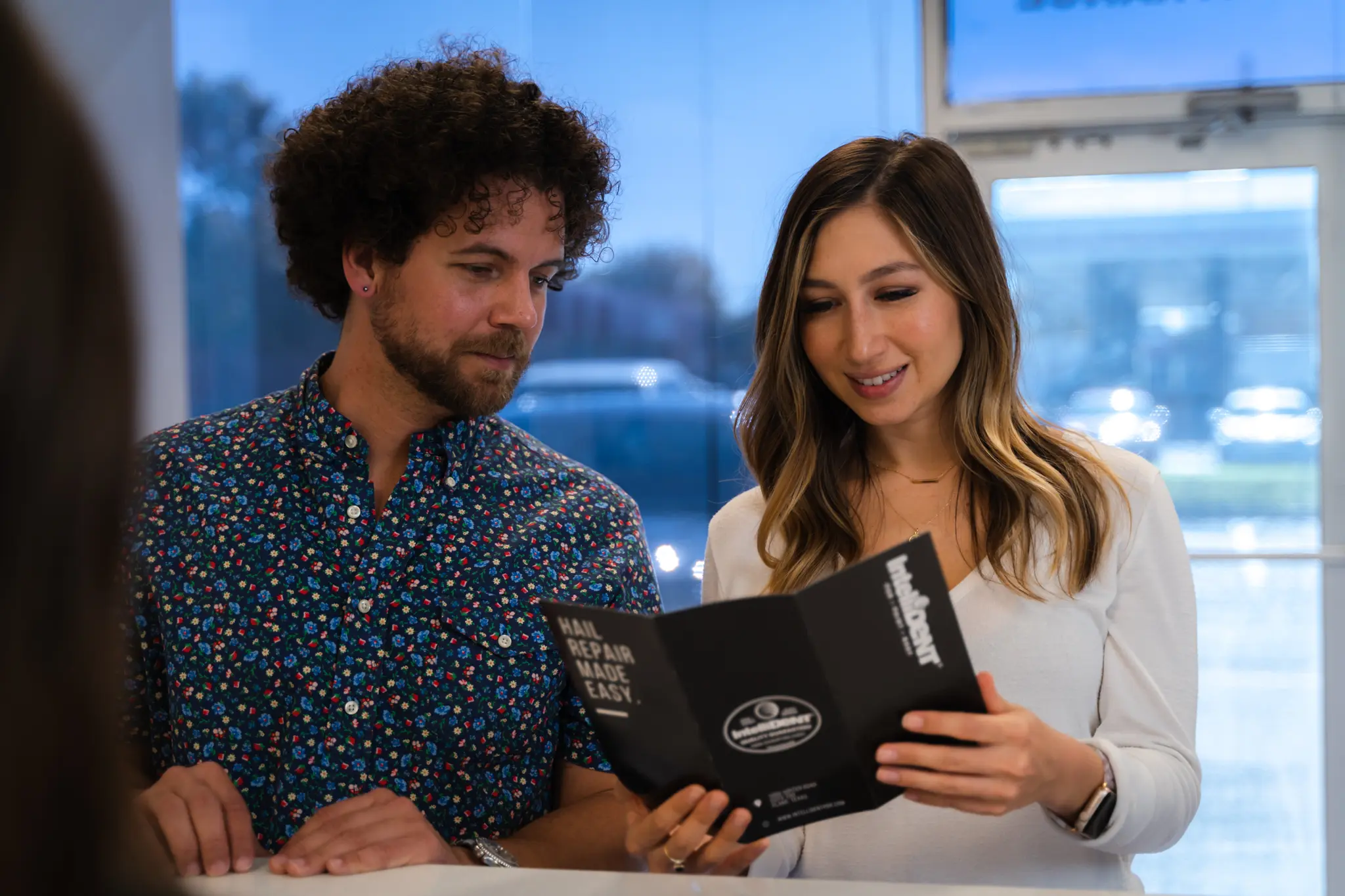 IntelliDent customers looking at dent repair pamphlet